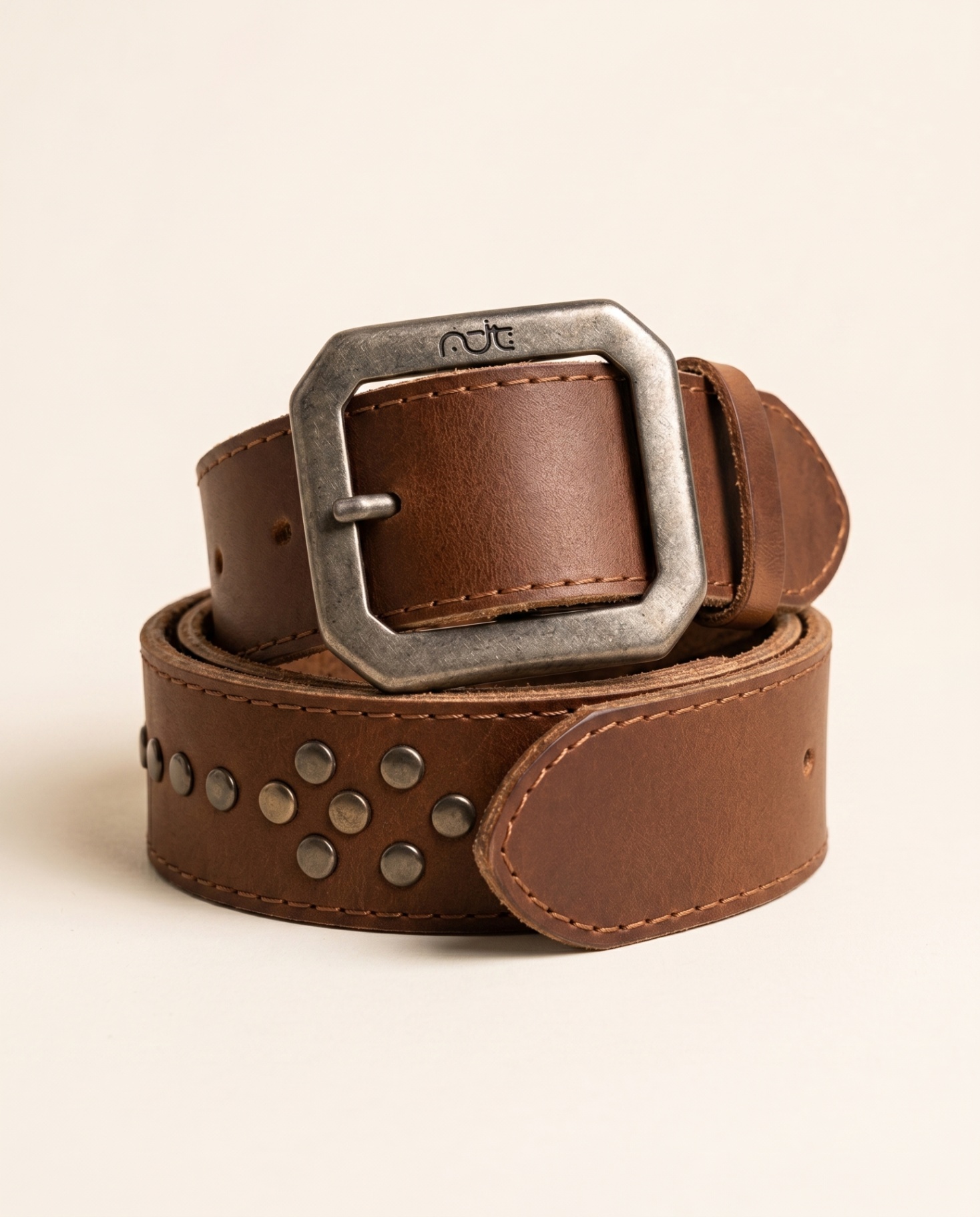 Brown leather belt with metal flower-like stud arrangement and silver buckle.