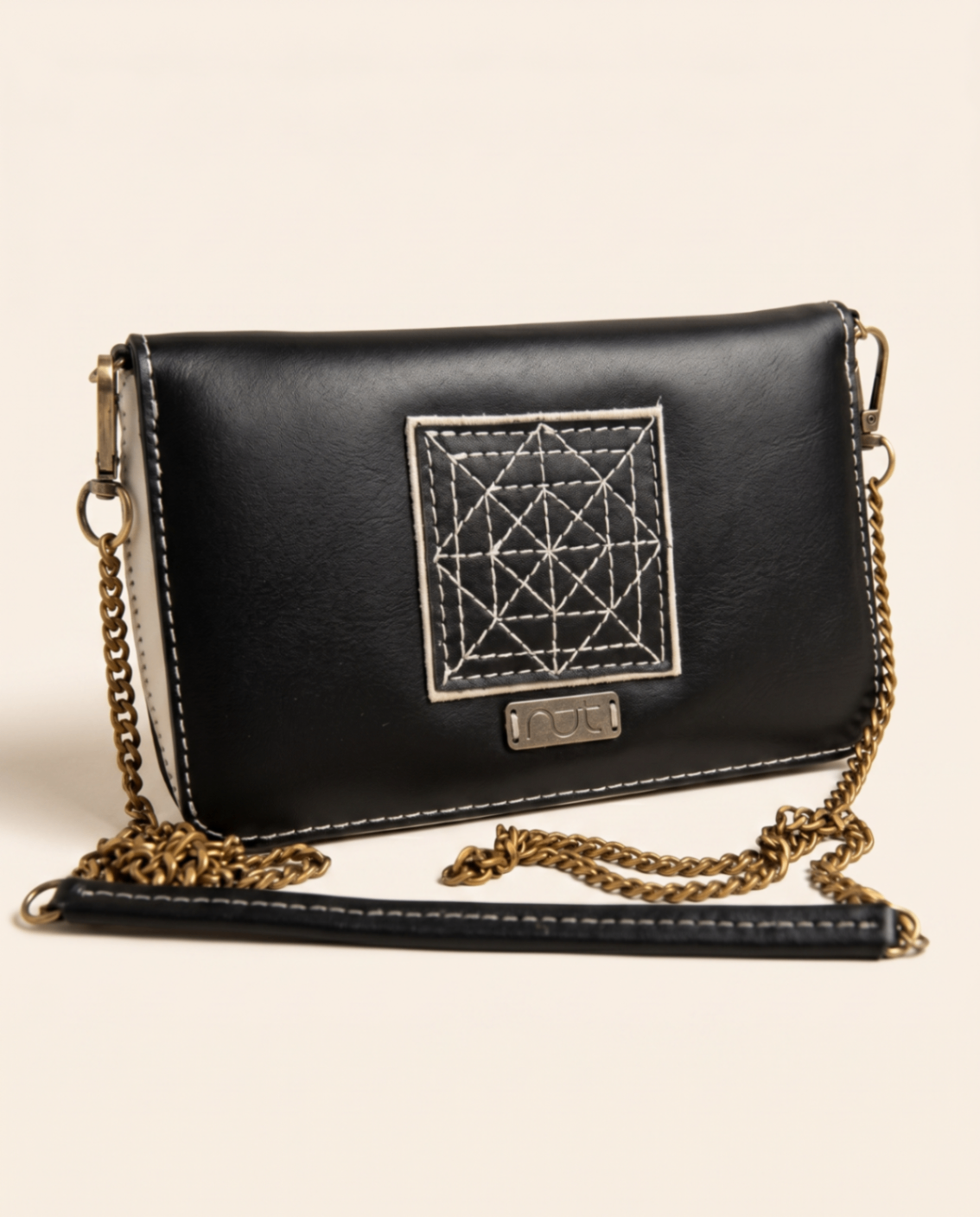 Black convertible purse with stitched geometric motif and chain strap.