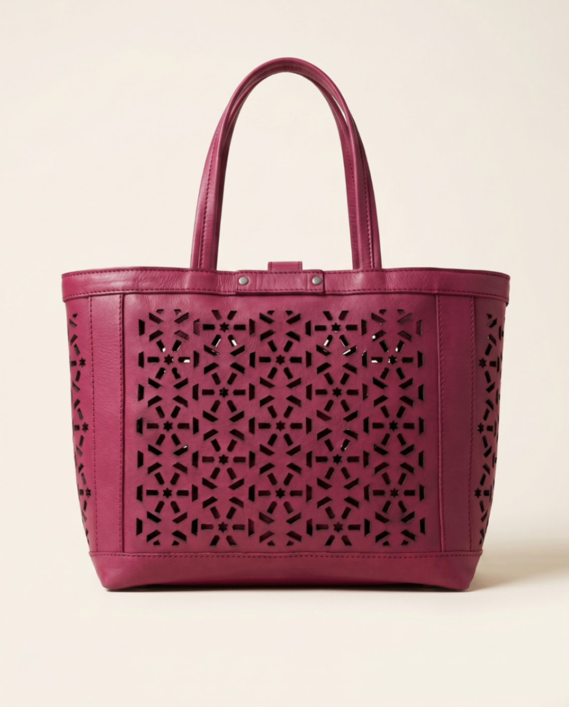 Plum leather tote with mashrabiya cutwork panels.